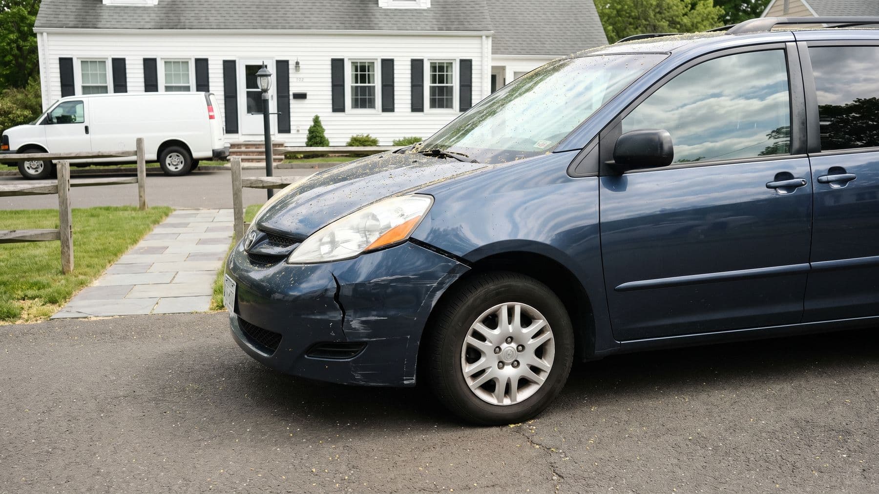 Illustration: a dark blue minivan in the driveway of a white Cape Cod house in Connecticut, a split-rail fence and a lamppost by the walk.