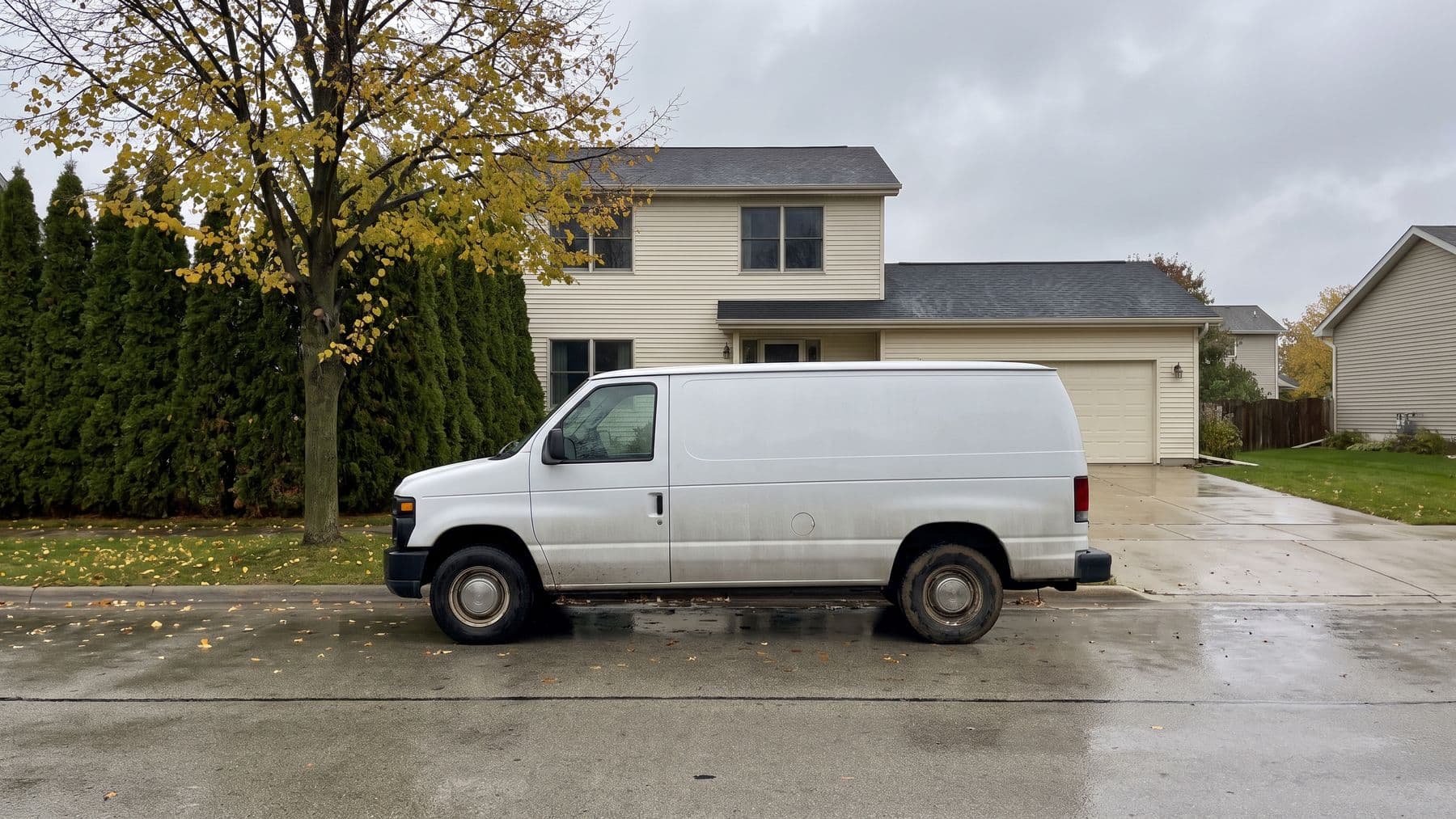 Illustration: a white cargo van parked at the curb in front of a cream two-story house in suburban Milwaukee, a maple dropping yellow leaves.
